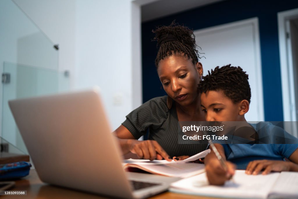 Mother helping son with homework at home