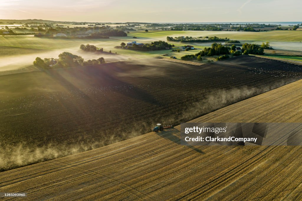 Landbouwer die een gebied ploegt.