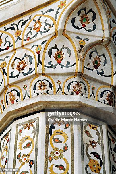 dado frames and archway spandrels decorated with pietra dura inlays of highly stylised vines, flowers and fruits. the inlay stones are yellow marble, jasper and jade, levelled and polished to the surface of the walls. red fort of agra, india. - agra stock-fotos und bilder