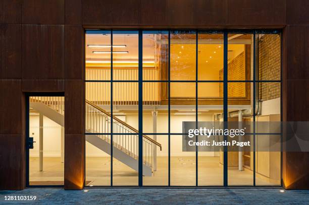 illuminated empty office building at dusk - revestimento equipamento de construção - fotografias e filmes do acervo