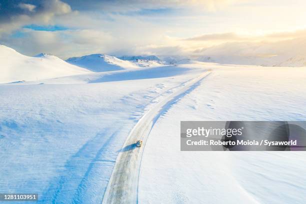 car on the snowy road towards nordkapp, finnmark, norway - snow covered road stockfoto's en -beelden