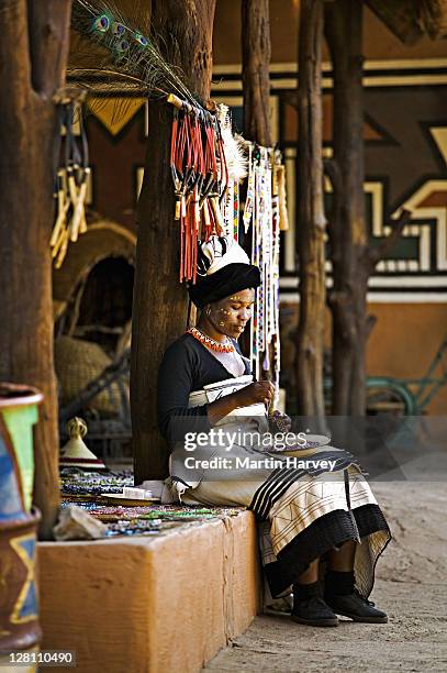 xhosa woman in traditional dress, doing beadwork. lesedi cultural village near johannesburg, south africa. - xhosa volk stock-fotos und bilder