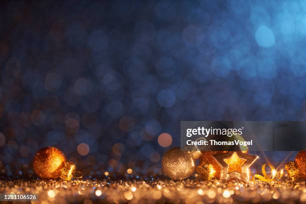 sprankelende gouden kerst ornamenten - decoratie ontscherp bokeh achtergrond - christmas dark stockfoto's en -beelden