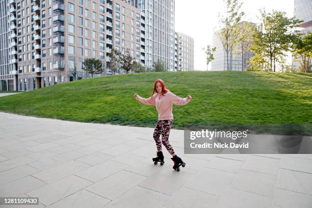 young woman rollerblading in an empty urban environment - roller skates stock pictures, royalty-free photos & images