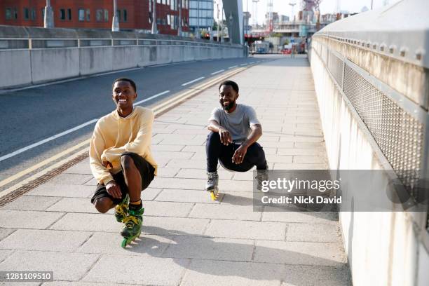 two happy inline skaters crossing over an urban city bridge - inline skating - fotografias e filmes do acervo