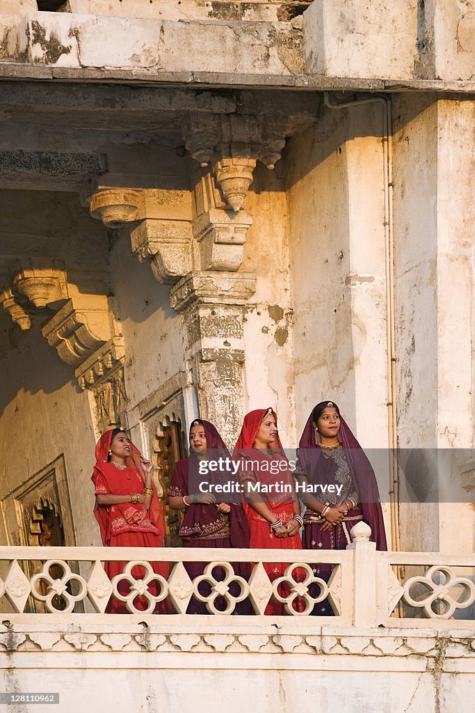 Four women in traditional attire standing on a balcony of the City Palace Complex. Udaipur, India. (MR) (PR: Property Released)