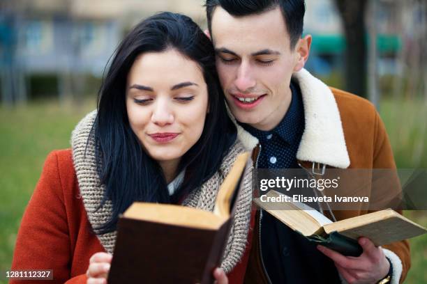 young couple reading books - poeta imagens e fotografias de stock