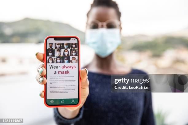 woman showing mobile phone screen with news related to covid-19 - leopatrizi contact tracing stock pictures, royalty-free photos & images