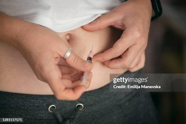 close up of woman applying injection with syringe - hormone stock-fotos und bilder