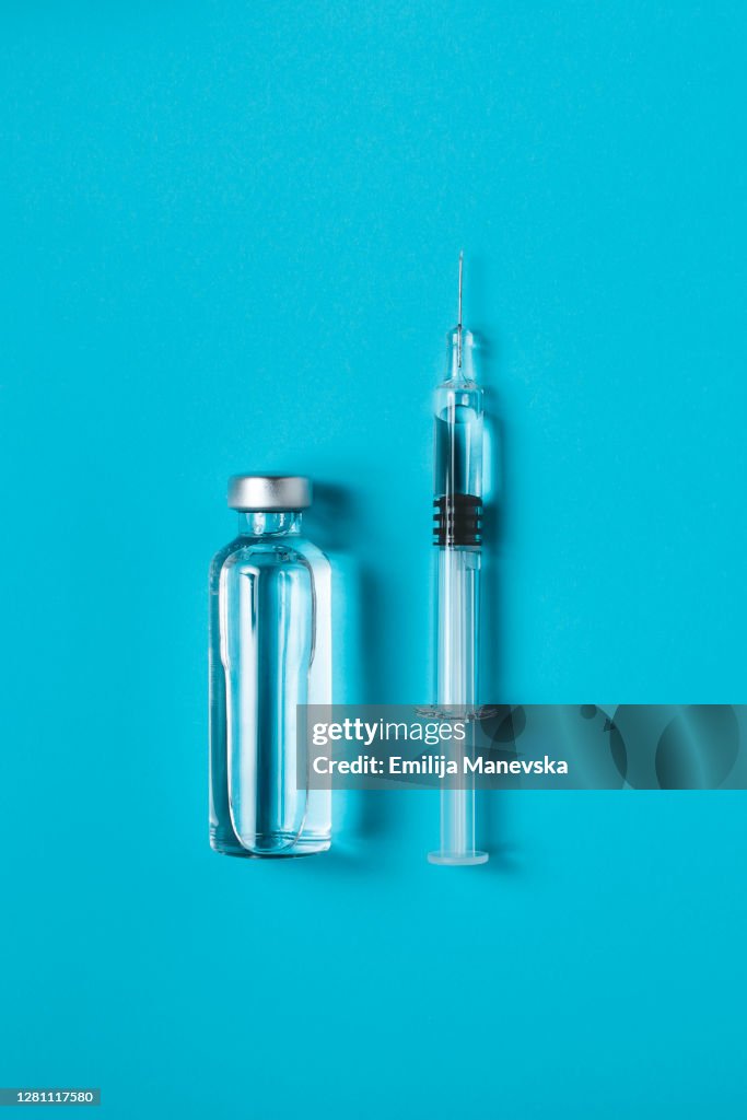 Syringe and ampoule on blue background