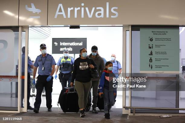 Passengers from Qantas flight QF583 are escorted to waiting Transperth buses by Police Officers after being processed following their arrival at...