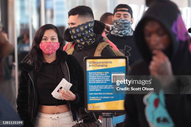 Passengers wait in line for screening at a Transportation Security Administration checkpoint at O'Hare International Airport on October 19, 2020 in...