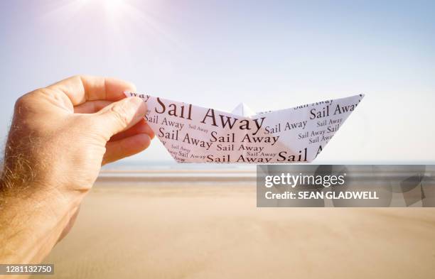 man holding paper boat - paper boat stock-fotos und bilder