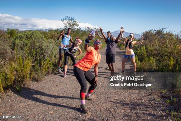 a multi-ethnic group of hikers taking a group selfie. - group of people running stock pictures, royalty-free photos & images