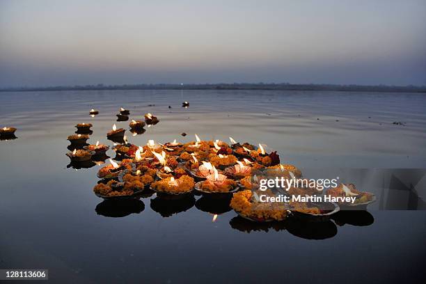 deepak in the ganges river. the deepak or oil lamps are used as an offering to the ganges river or great mother at sunrise and sunset in respect of mother goddess ganges, god shiva and the rising sun. varanasi, india. - ganges stockfoto's en -beelden