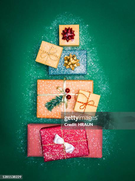 weihnachtsgeschenke auf einem grünen tisch in form von weihnachtsbaum - christmas still life stock-fotos und bilder