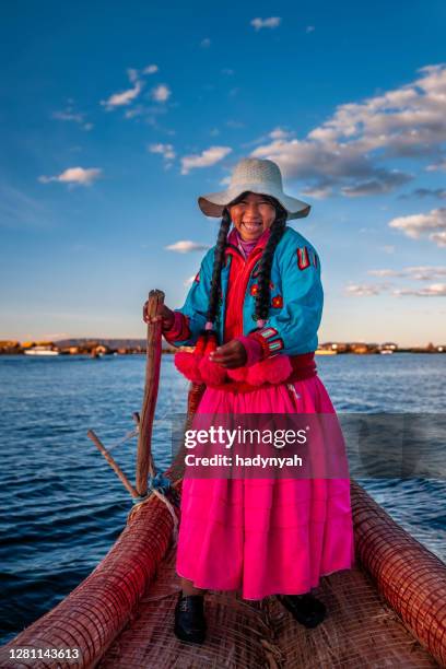 mujer peruana navegando entre islas flotantes de uros, lago tititcaca - peruvian culture fotografías e imágenes de stock