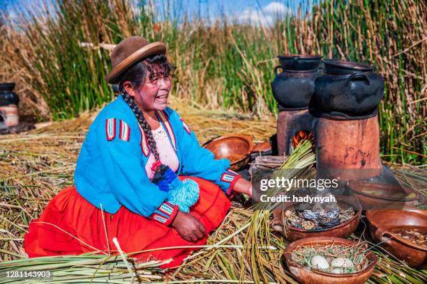 peruanische frau kochen auf uros schwimmende insel, tititcaca - aymara indian stock-fotos und bilder