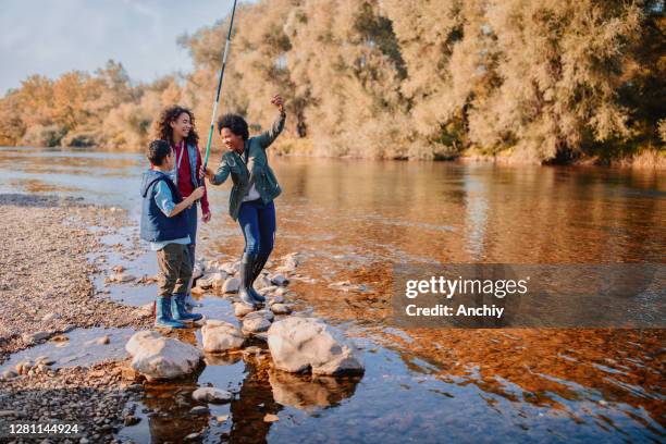 smiling family fishing by the river - staycation autumn stock pictures, royalty-free photos & images