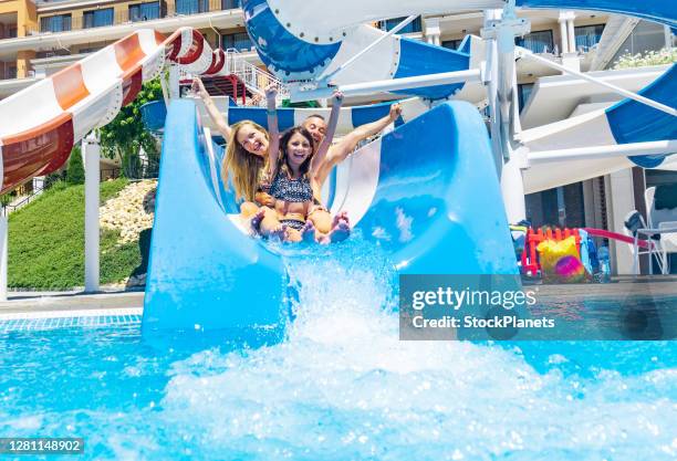 gelukkige familie in aquapark - child slide stockfoto's en -beelden