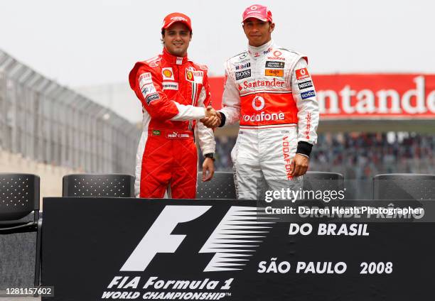 Brazilian Ferrari Formula One driver Felipe Massa shakes hands with World Drivers' Championship rival British McLaren driver Lewis Hamilton before...