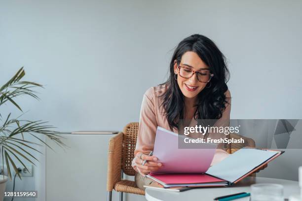 junge geschäftsfrau liest dokumente/berichte bei der arbeit (copy space) - bürokratie stock-fotos und bilder