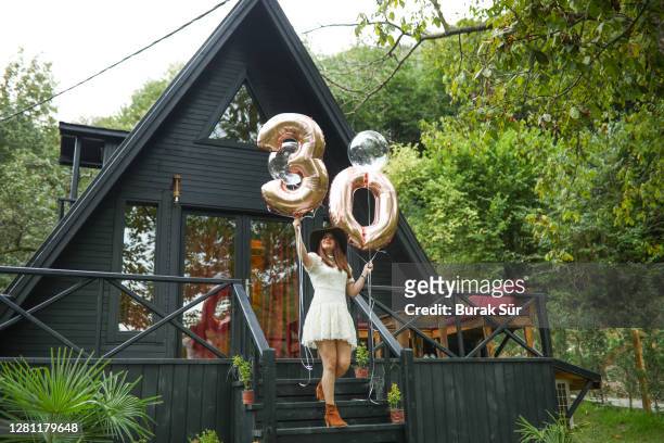30 jahre geburtstagsparty und schöne frau vor dem bungalowhaus - 30 34 years stock-fotos und bilder