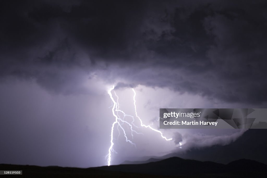 Thunderstorm sky with lightning bolts over the Drakensberg mountains. Drakensberg, South Africa
