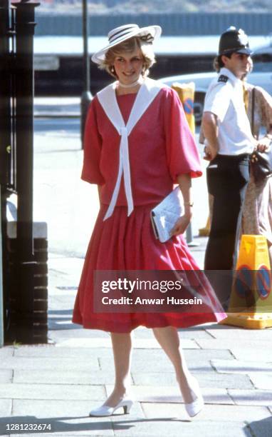 Diana, Princess of Wales, wearing a pink sailor style dress with a white collar and a white hat, attends the wedding of her former flatmate Carolyn...