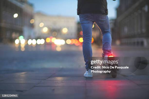 man using electric push scooter - trotinete imagens e fotografias de stock