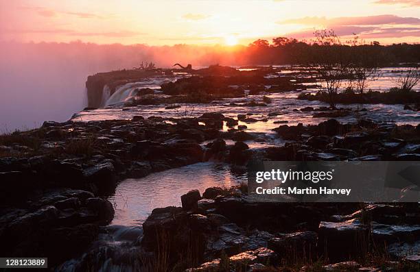 victoria falls at sunset livingstone, zambia, southern africa - victoria falls sunset stock pictures, royalty-free photos & images