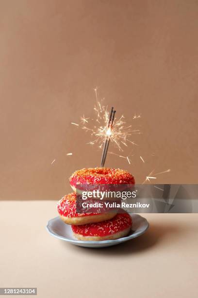 birthday doughnuts with sparkler on the beige background - plain donut stock pictures, royalty-free photos & images