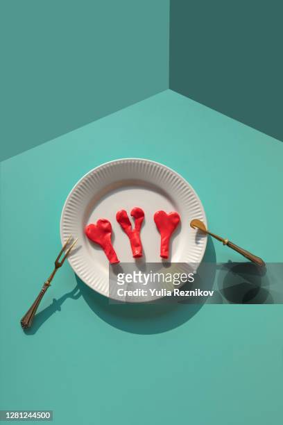 two heart shapes and one broken heart on a plate on the blue background - assiette cassée photos et images de collection