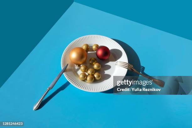 christmas balls on the plate on the blue background - küchenmesser freisteller stock-fotos und bilder