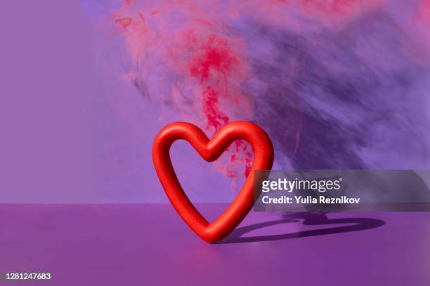 exploding heart shape on the purple background - break up fotografías e imágenes de stock