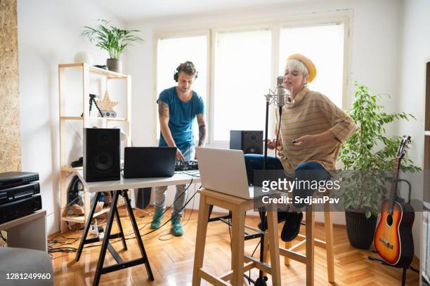 two caucasian musicians making their new song in the home music studio - woman in guitar making studio stock pictures, royalty-free photos & images
