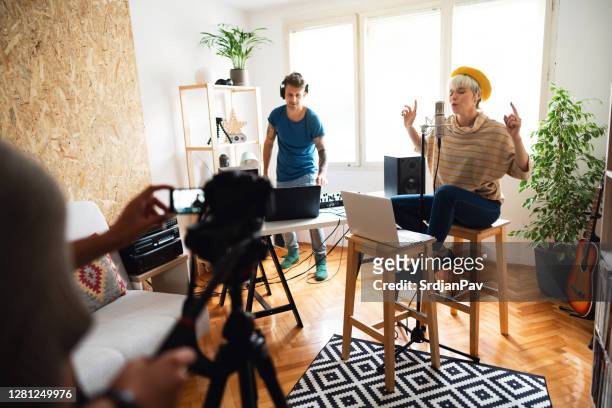 two caucasian musicians recording video for their new song in the music studio - electronic music stock pictures, royalty-free photos & images