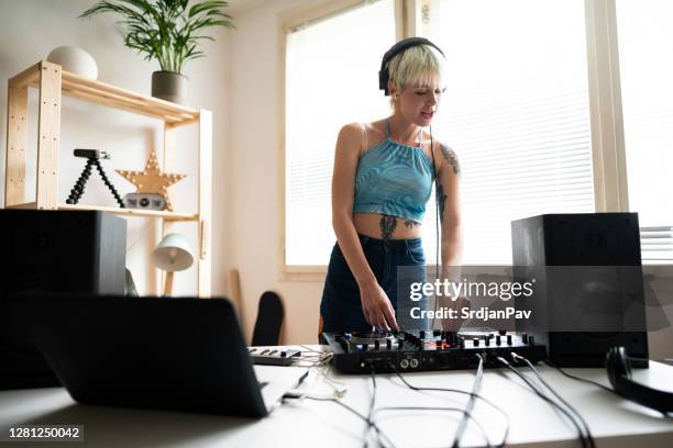 young female dj and producer practicing mixing music at home - music producer stock pictures, royalty-free photos & images