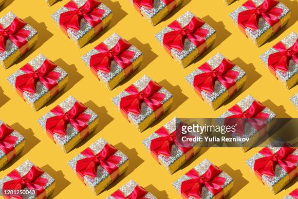 repeated silver gift box on the yellow background - regalo foto e immagini stock