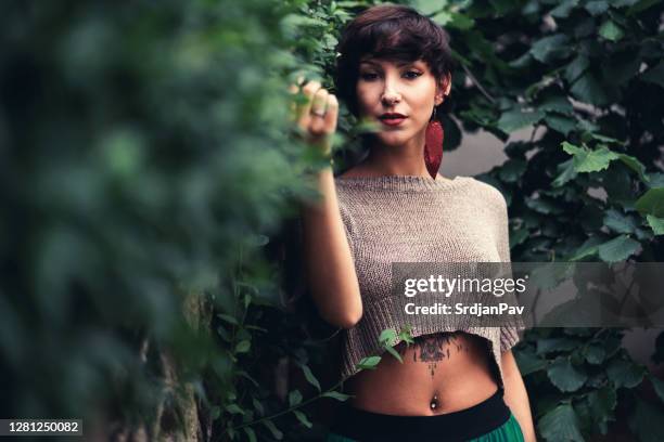 beautiful, tattooed, young woman with brown hair and brown eyes posing in the nature - short brown hair stock pictures, royalty-free photos & images