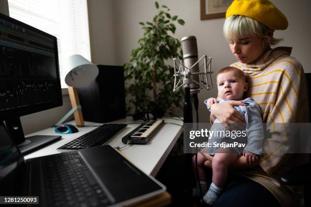 músico femenino sosteniendo a su bebé en el estudio de música - melody maker fotografías e imágenes de stock