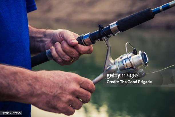 closeup of man adjusting fishing rod - cana de pesca imagens e fotografias de stock