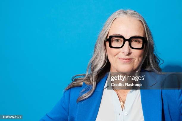 portrait of a confident, successful, happy mature woman - colored background bildbanksfoton och bilder