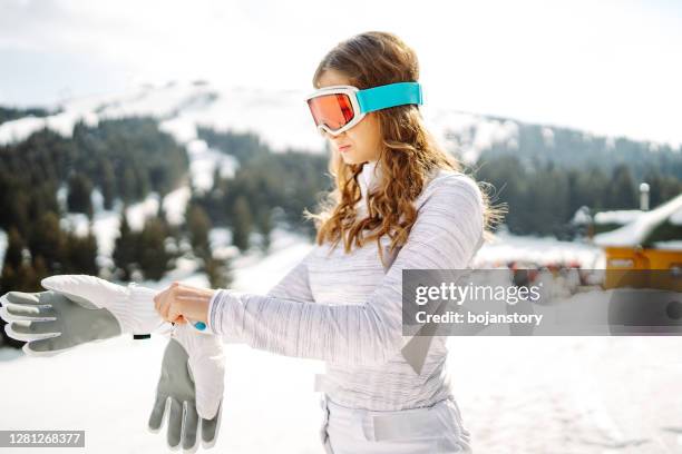 jeune femme se préparant pour le ski - paire de gants photos et images de collection
