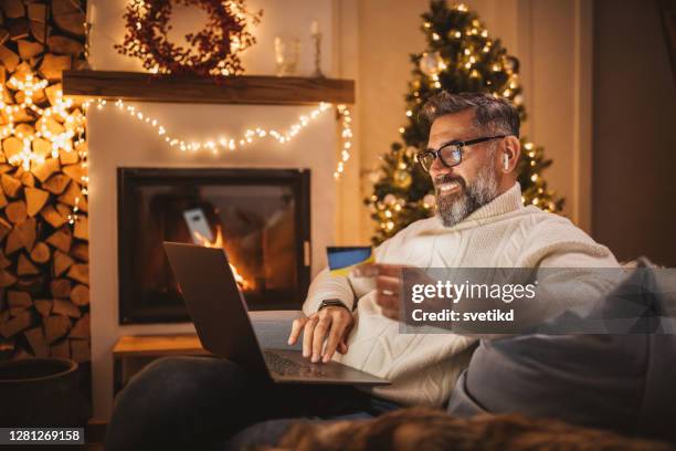 reifer mann arbeitet von zu hause aus - weihnachten laptop stock-fotos und bilder