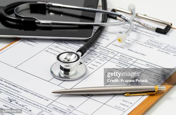 stethoscope on medical billing statement on table, all text is anonymous - exam paper stock pictures, royalty-free photos & images