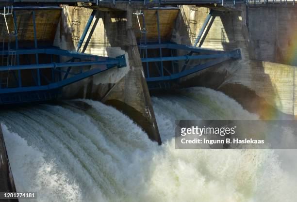 bodies of streaming water through locks in dam at power station. sunshine on water creating rainbow. - hydroelectric power station stock pictures, royalty-free photos & images