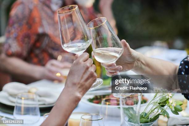 friends talking and dining outside on a warm summers day. - al fresco dining stock pictures, royalty-free photos & images