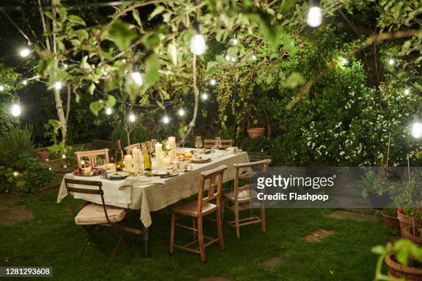 still life of a dressed dining table set for six people - garden lighting foto e immagini stock