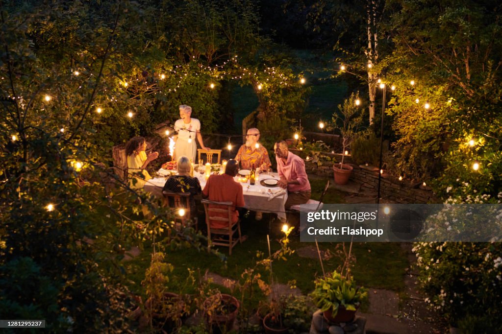 Friends talking and dining outside on a warm summers evening.